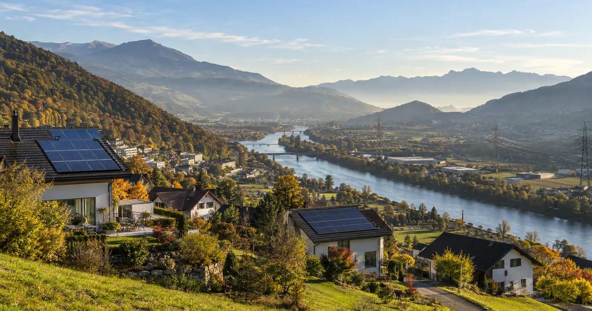 Toitures solaires dans une vallée frontalière suisse reliée par des lignes électriques aux collines voisines